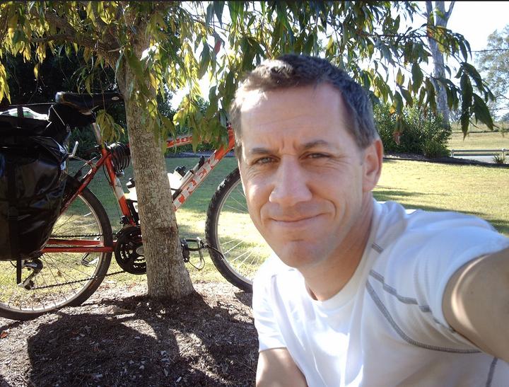 Me sitting in the shade of a eucalypt bush in Nerang. My bike behind me. Waiting for Matt